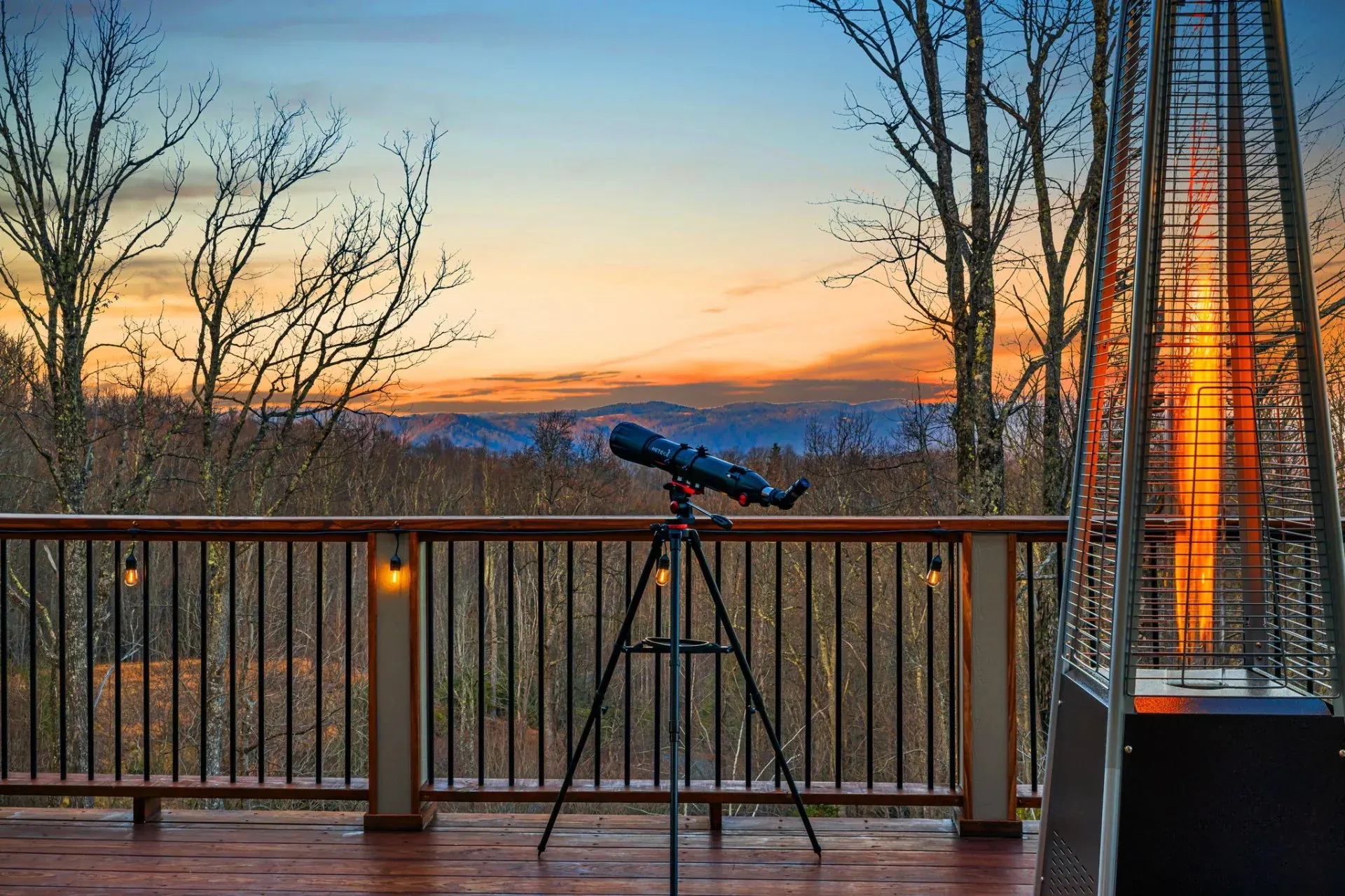 Deck with a telescope and patio heater overlooking a mountain sunset